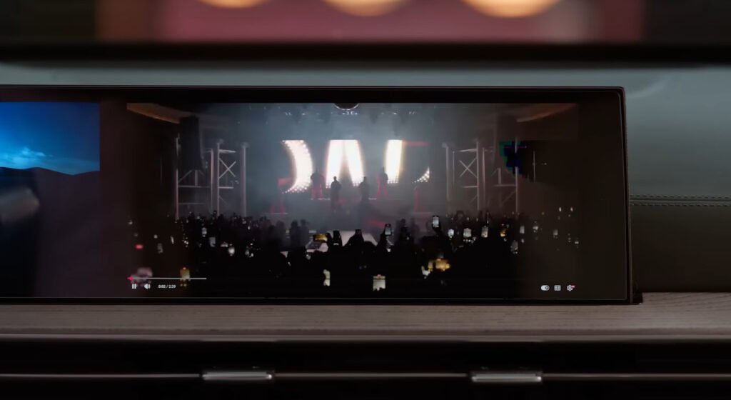 Tela panorâmica exibindo show com iluminação de palco e silhueta de plateia, demonstrando reprodução de vídeo em alta resolução.